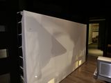 une pièce avec un mur blanc et une fenêtre ornée d'un rideau blanc