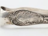a close up of a silver spoon on a white surface