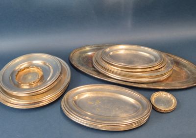beaucoup d'assiettes en argent posées sur une table