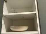 a cupboard with plates and bowls in it