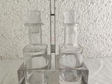 three glass bottles and a spoon sitting on a table