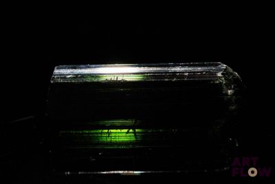 the green light shines on a piece of glass in the dark