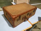 une valise marron posée sur une table blanche