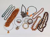 many necklaces and bracelets laid out on a table