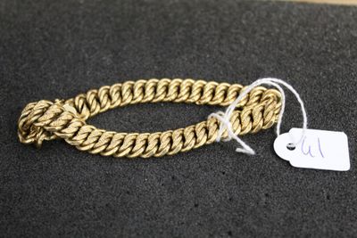 a close up of a gold bracelet with a tag on it