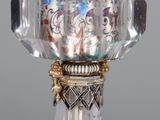 a glass vase with a gold and silver decoration on it