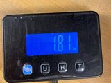 a digital clock on a table with a charger