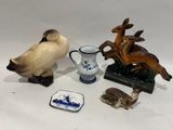 plusieurs figurines d'animaux et un vase posés sur une surface blanche