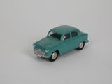 une petite voiture miniature posée sur une surface blanche