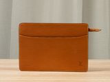 a brown leather wallet sitting on top of a wooden table