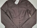 La veste est marron et comporte une étiquette blanche.