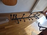 a guitar rack that is on the floor next to a guitar