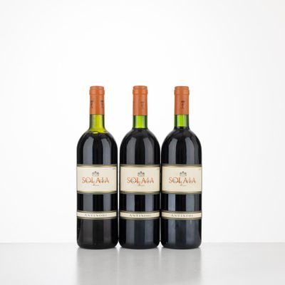 trois bouteilles de vin rouge posées sur une table