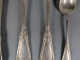five silver spoons and two silver spoons on a table