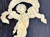 a picture of a carved angel on a wooden surface
