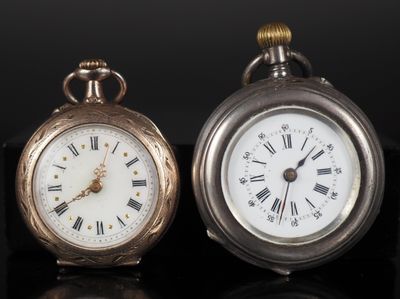 deux horloges posées l'une à côté de l'autre sur une surface noire