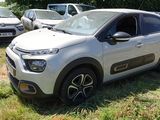 une petite voiture blanche garée dans l'herbe à côté d'autres voitures