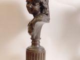 a bronze bust of a young girl on a pedestal