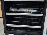 a black and white oven with many racks of food inside of it