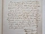 un livre ouvert, sur lequel repose une lettre manuscrite, posé sur une table