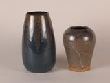 two vases sitting next to each other on a white surface