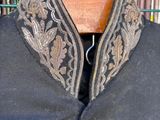 a close up of a black jacket with gold embroidery on it