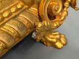 a gold vase with a bird on top of it