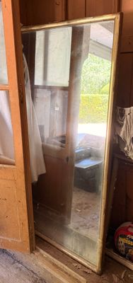 un grand miroir posé dans un coin de la pièce