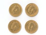 quatre types différents de pièces d'or sur une surface blanche