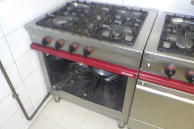 deux cuisinières qui se trouvent dans une cuisine équipée de poignées rouges