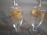 two glass vases with gold designs on them