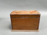 an old wooden box with a marble top sitting on a table
