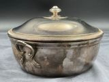 a silver bowl with a lid on a table