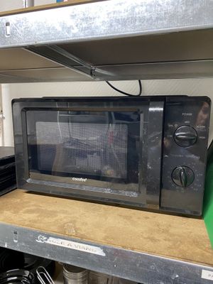 a black microwave sitting on a shelf in a kitchen