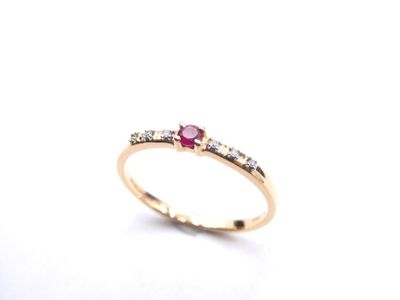 a close up of a gold ring with a ruby and white diamond