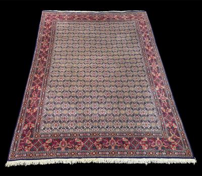 un ancien tapis persan à motifs rouges et bleus