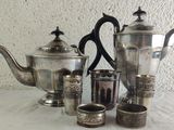 a lot of silver teapots and cups on a table