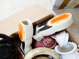 a box full of dirty dishes and cups on the floor