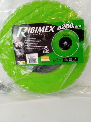 une bobine verte dans un sac en plastique posée sur une surface blanche