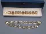 deux paires de bracelets en or dans un coffret bleu posé sur une table