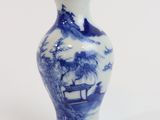 a blue and white vase with a picture of a boat in the water