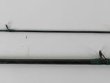 two fishing rods on a white surface next to each other