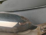a silver spoon sitting on top of a table next to a knife