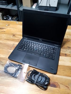 a laptop computer that is sitting on a wooden table
