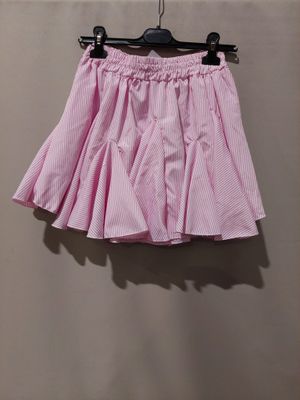 La jupe rose est suspendue à un cintre contre le mur