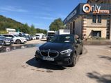 the black bmw car is parked in front of a building
