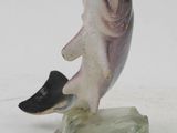 a small figurine of a dolphin on a rock