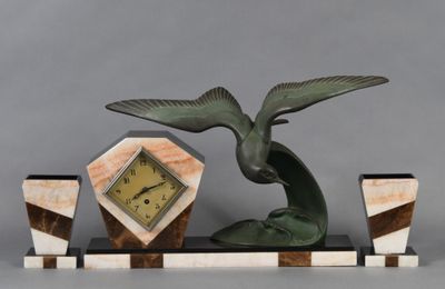 une statue représentant un oiseau avec une horloge, posée sur un socle