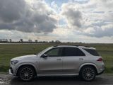 a white mercedes suv parked on the side of the road