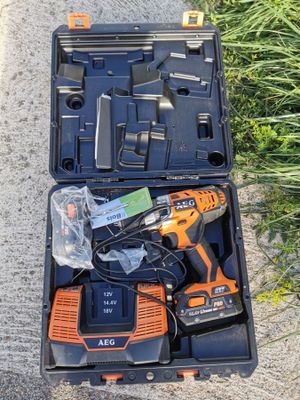 an orange and black tool kit sitting on the ground next to some grass